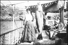 photo of Woman Standing Next to Large Fish
